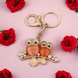 Ключодържател с две украсени сови, символизиращ семейната връзка