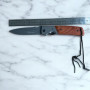 Дървена дръжка и въженце за захващане на нож Browning Нож Browning върху мраморен фон с метална линийка за размер
