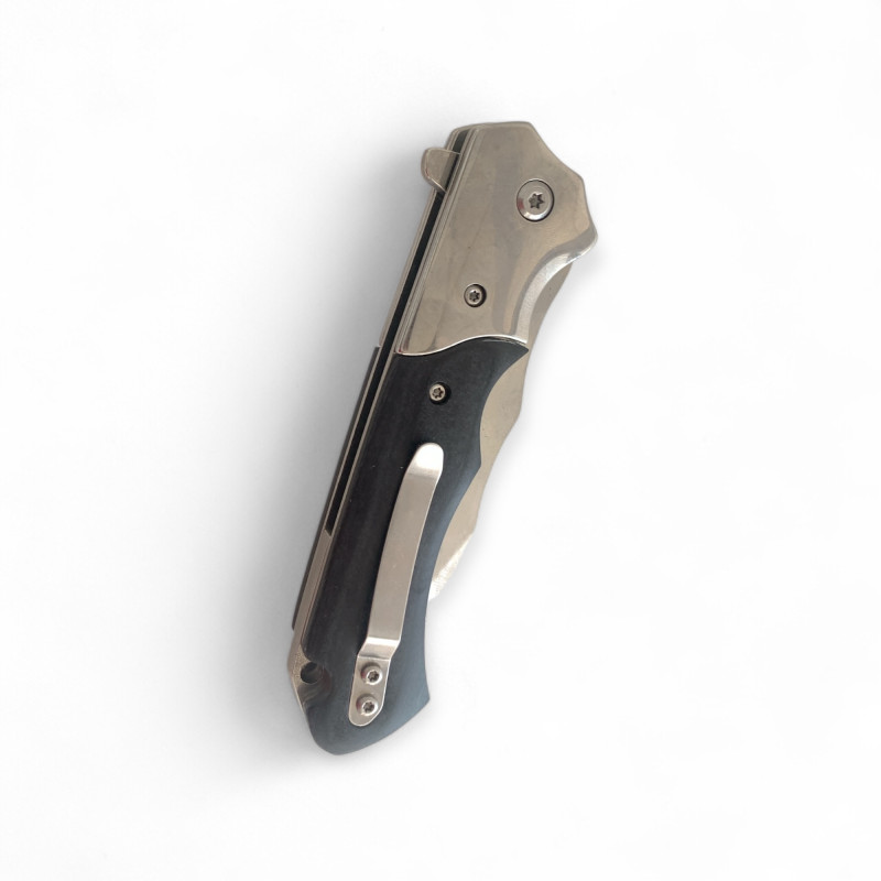 Нож Browning Silver Edge изправен върху дървена маса с отблясъци от светлина Сгъваем нож Browning със сребристо острие и черна дръжка върху светла повърхност