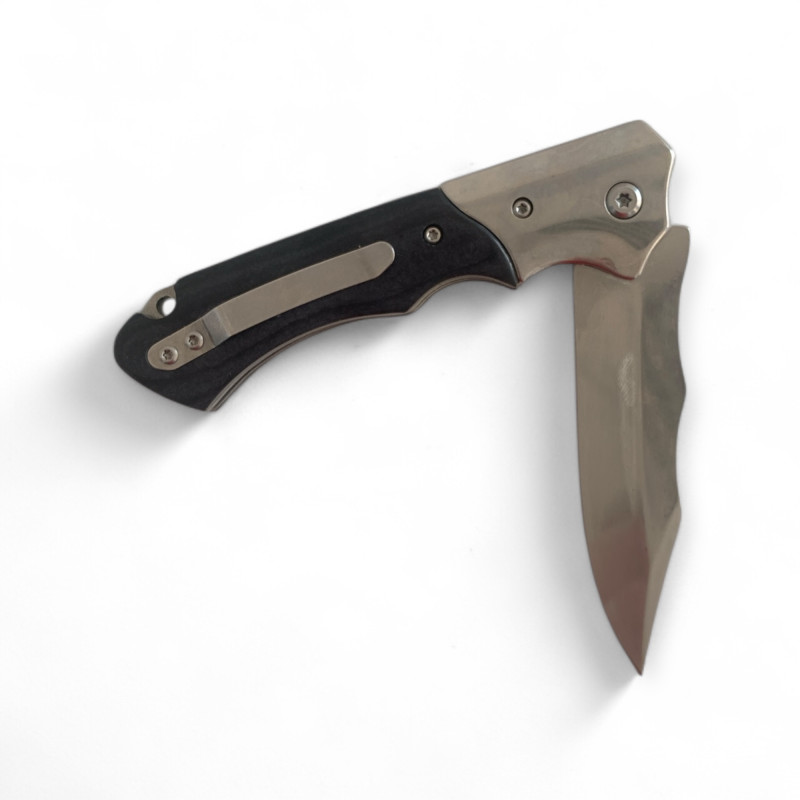 Нож Browning Silver Edge изправен върху дървена маса с отблясъци от светлина Сгъваем нож Browning със сребристо острие и черна дръжка върху светла повърхност