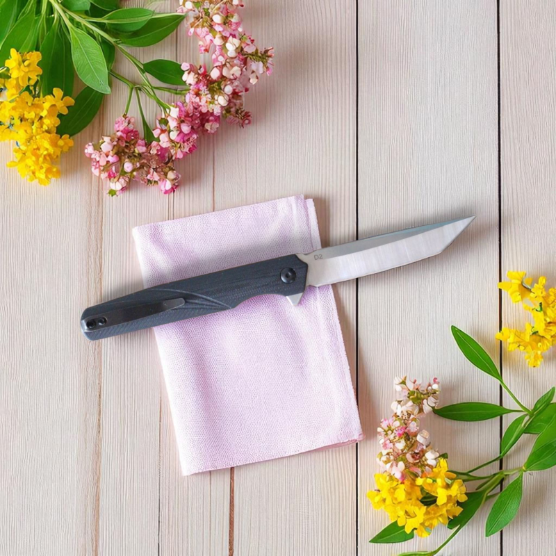 Джобен нож VexKnives в отворено положение на светъл фон Сгъваем нож VexKnives с танто острие от D2 стомана