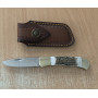 Ловен нож Elk Horn 195 с кожена кания върху дърво сред гора