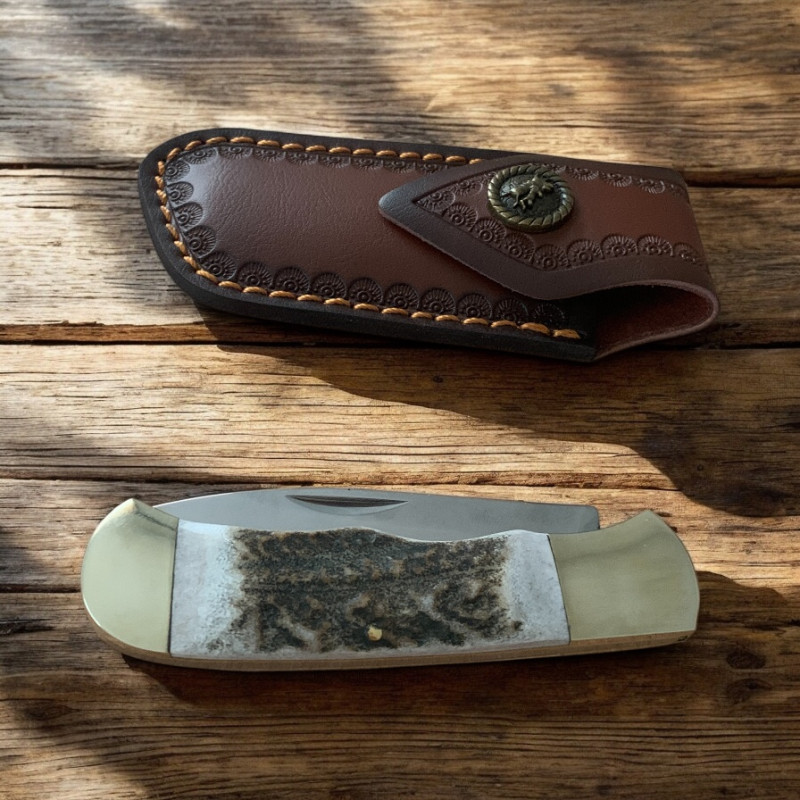 Ловен нож Elk Horn 195 с кожена кания върху дърво сред гора