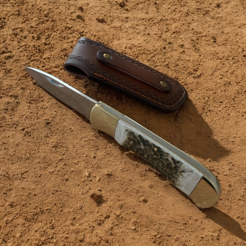Ловен нож Elk Horn 195 с кожена кания върху дърво сред гора