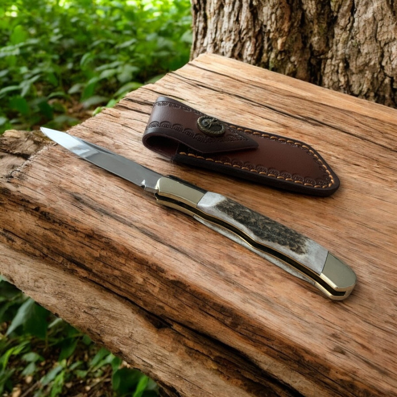 Ловен нож Elk Horn 195 с кожена кания върху дърво сред гора