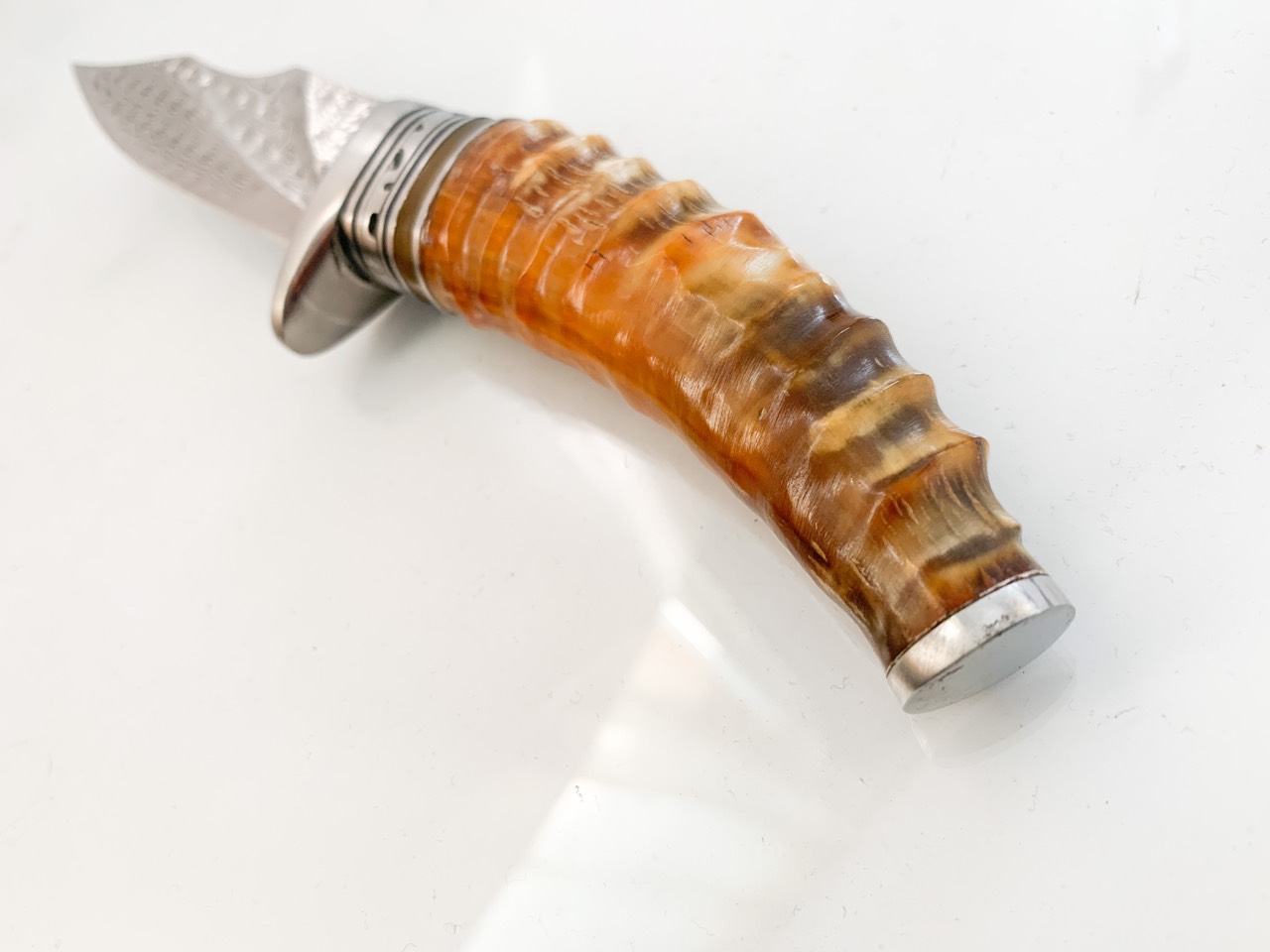 Ловен нож ръчно направен от дамаска японска стомана,дръжка от кориан имитиращ еленов рог и метален гард