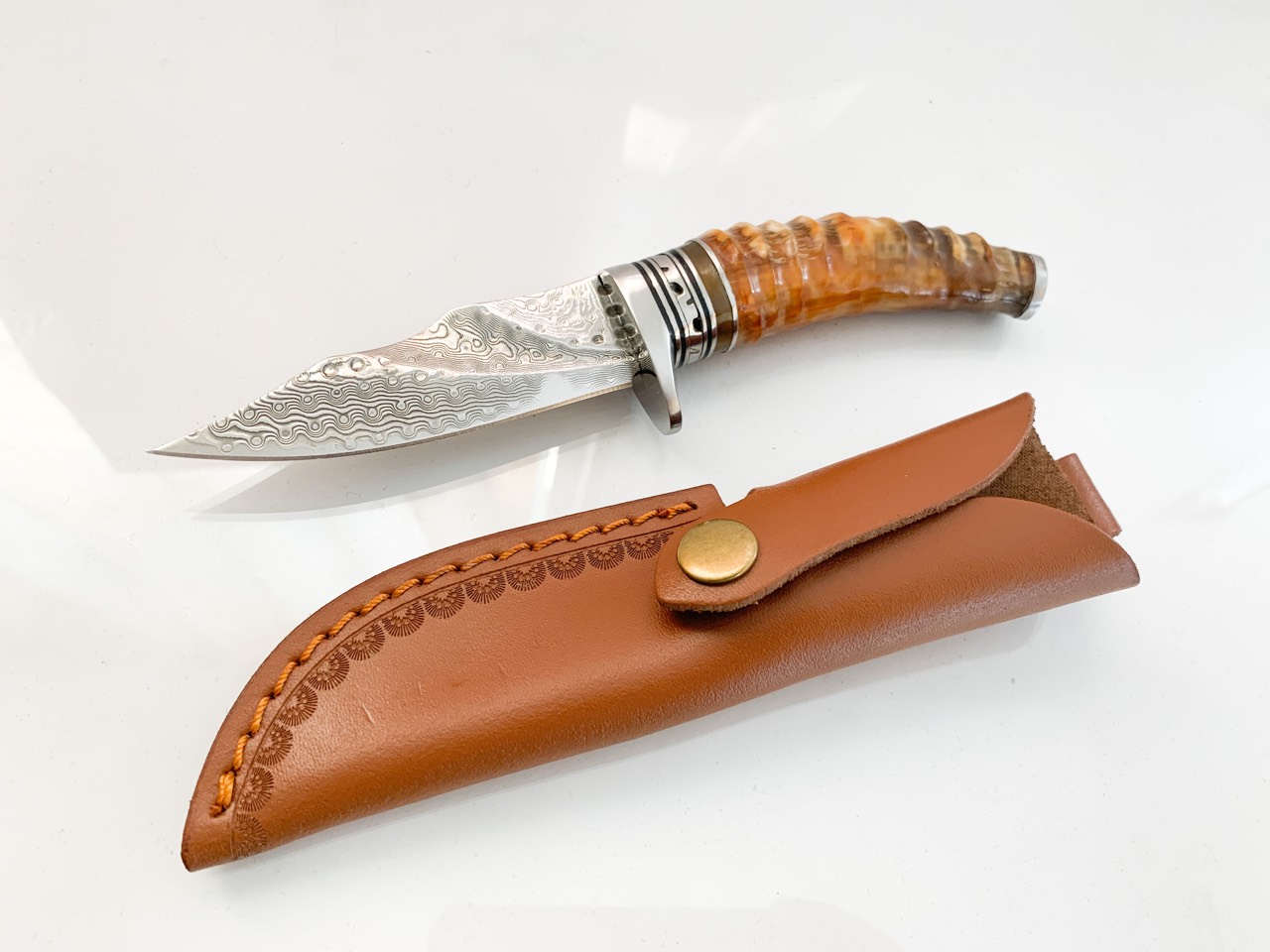 Ловен нож ръчно направен от дамаска японска стомана,дръжка от кориан имитиращ еленов рог и метален гард