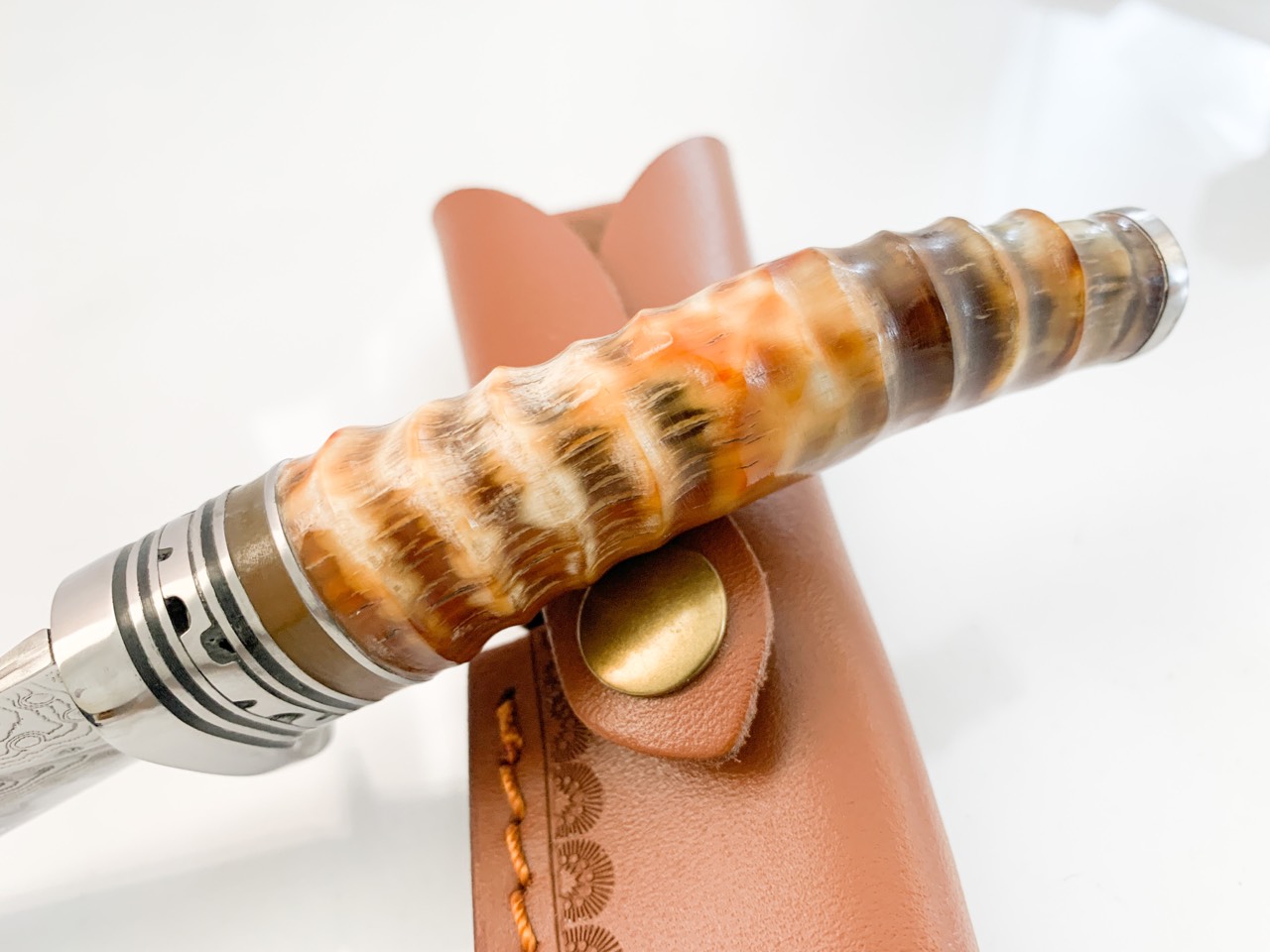 Ловен нож ръчно направен от дамаска японска стомана,дръжка от кориан имитиращ еленов рог и метален гард