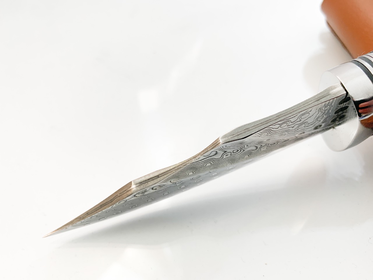 Ловен нож ръчно направен от дамаска японска стомана,дръжка от кориан имитиращ еленов рог и метален гард