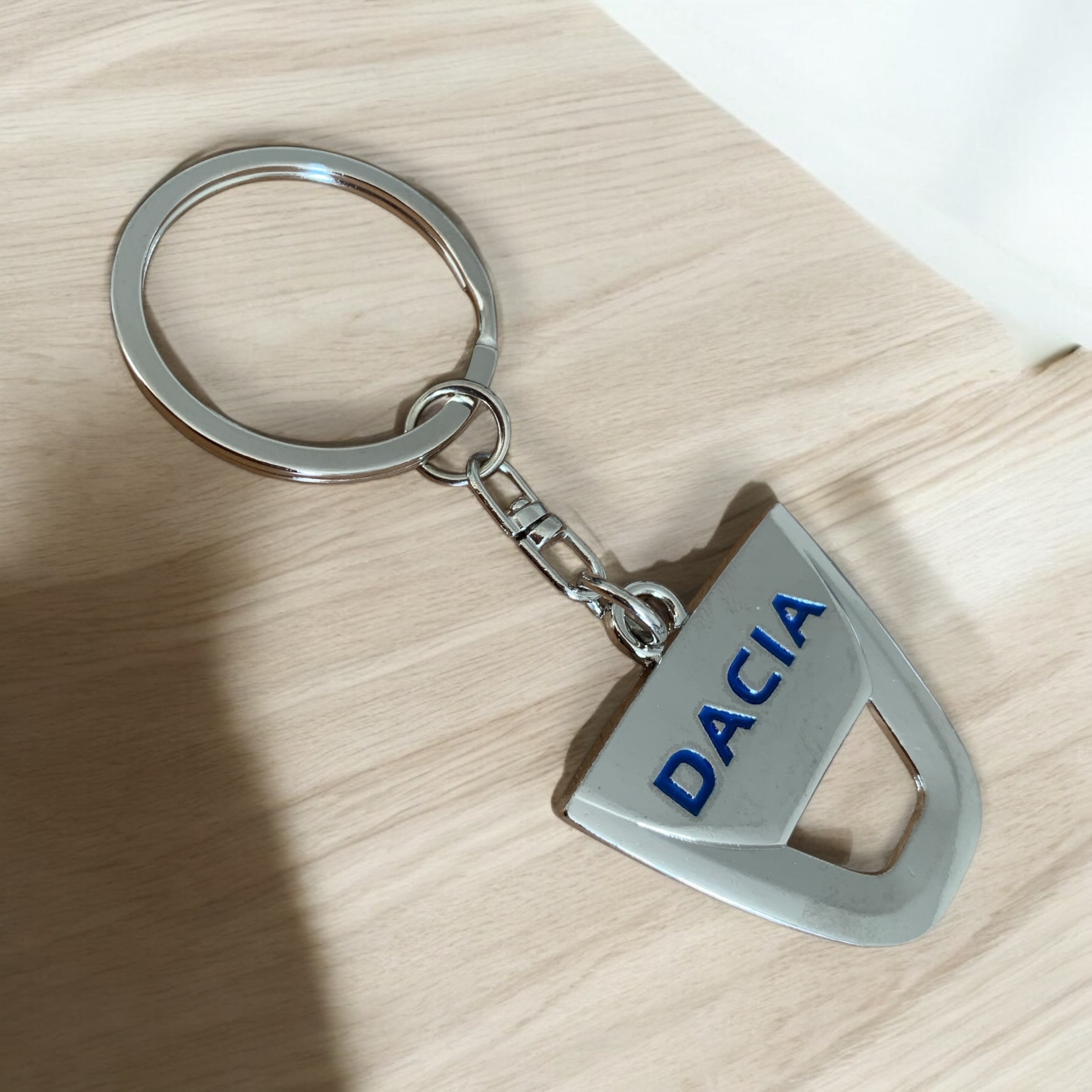 Стилен ключодържател Dacia върху дървена повърхност