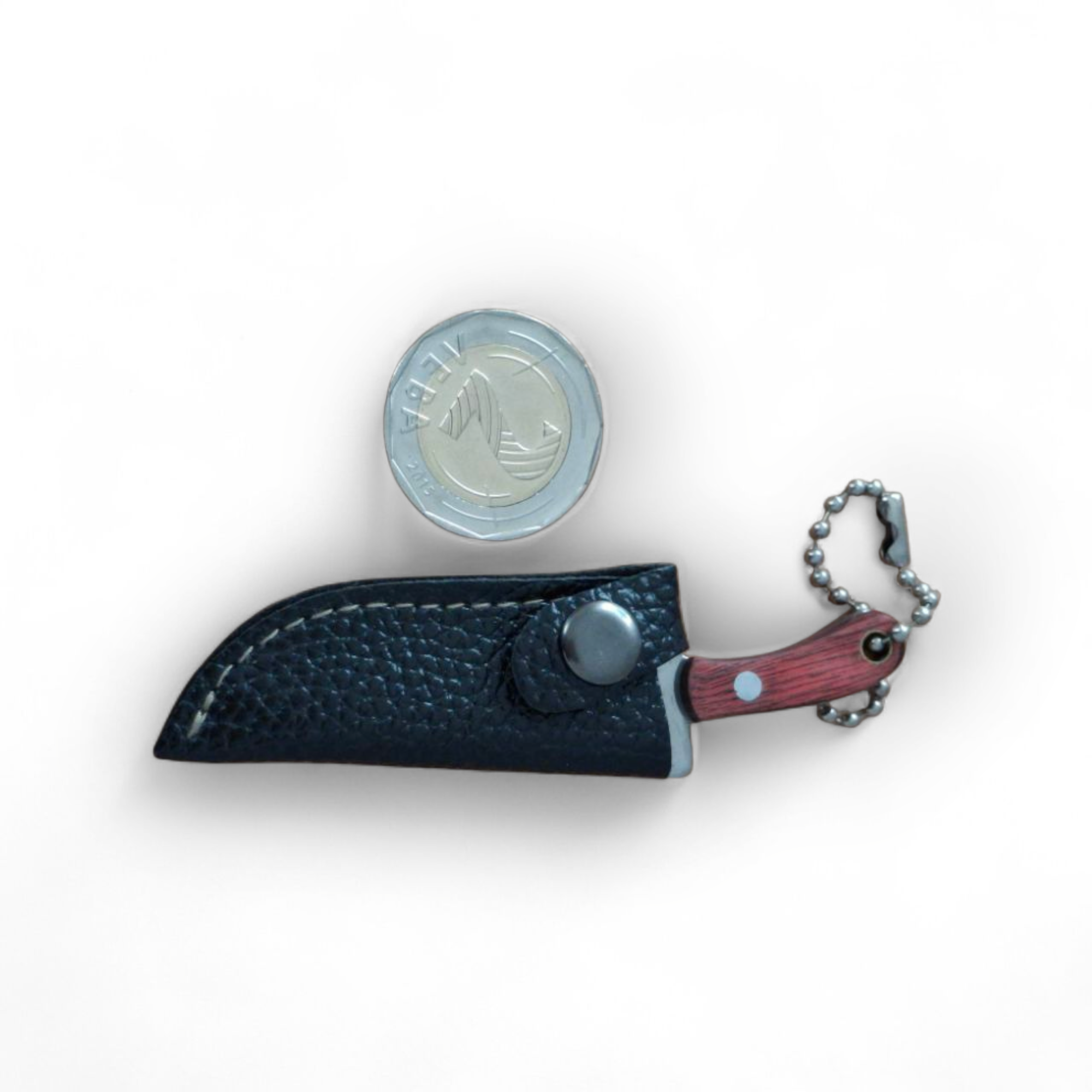 Джобен ловен нож с верижка и кожен калъф върху бял плат