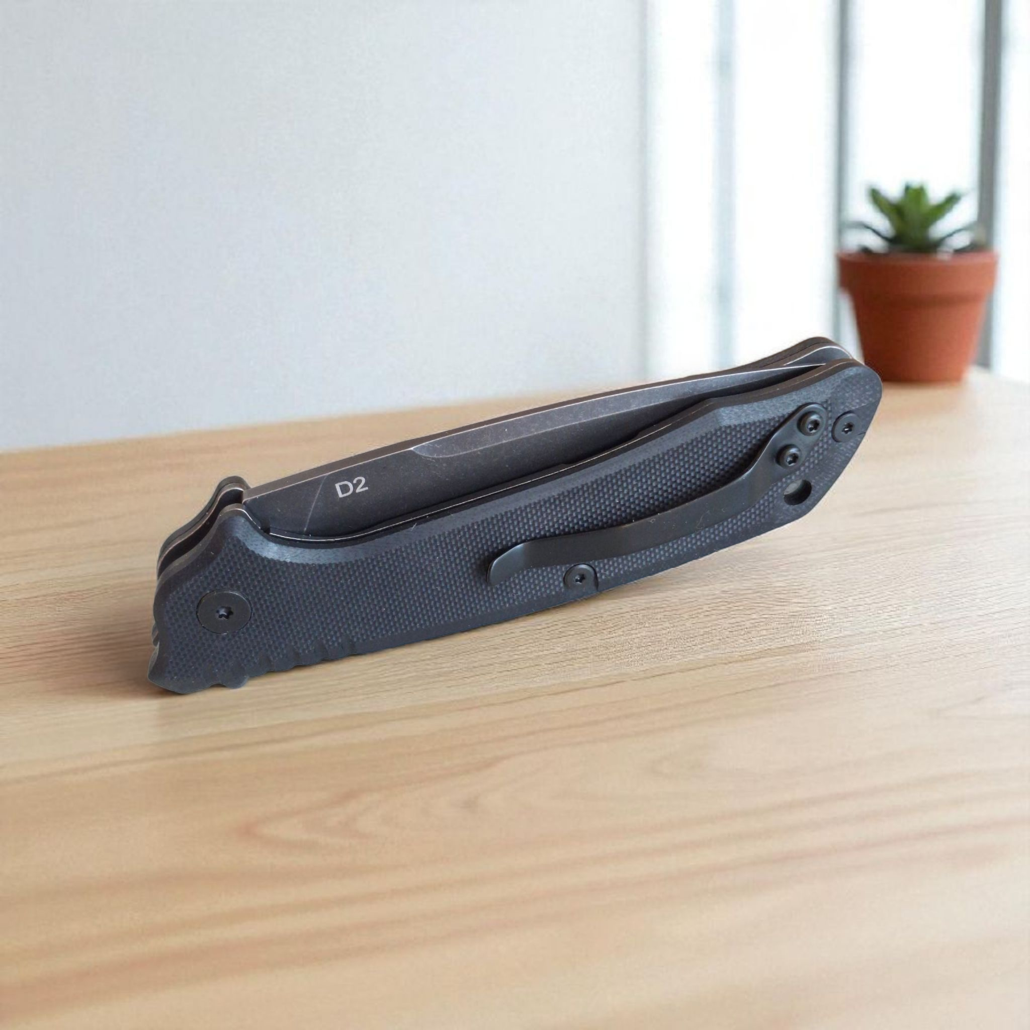 Сгънат нож Apex Cutlery на дървена маса, изглед отпред