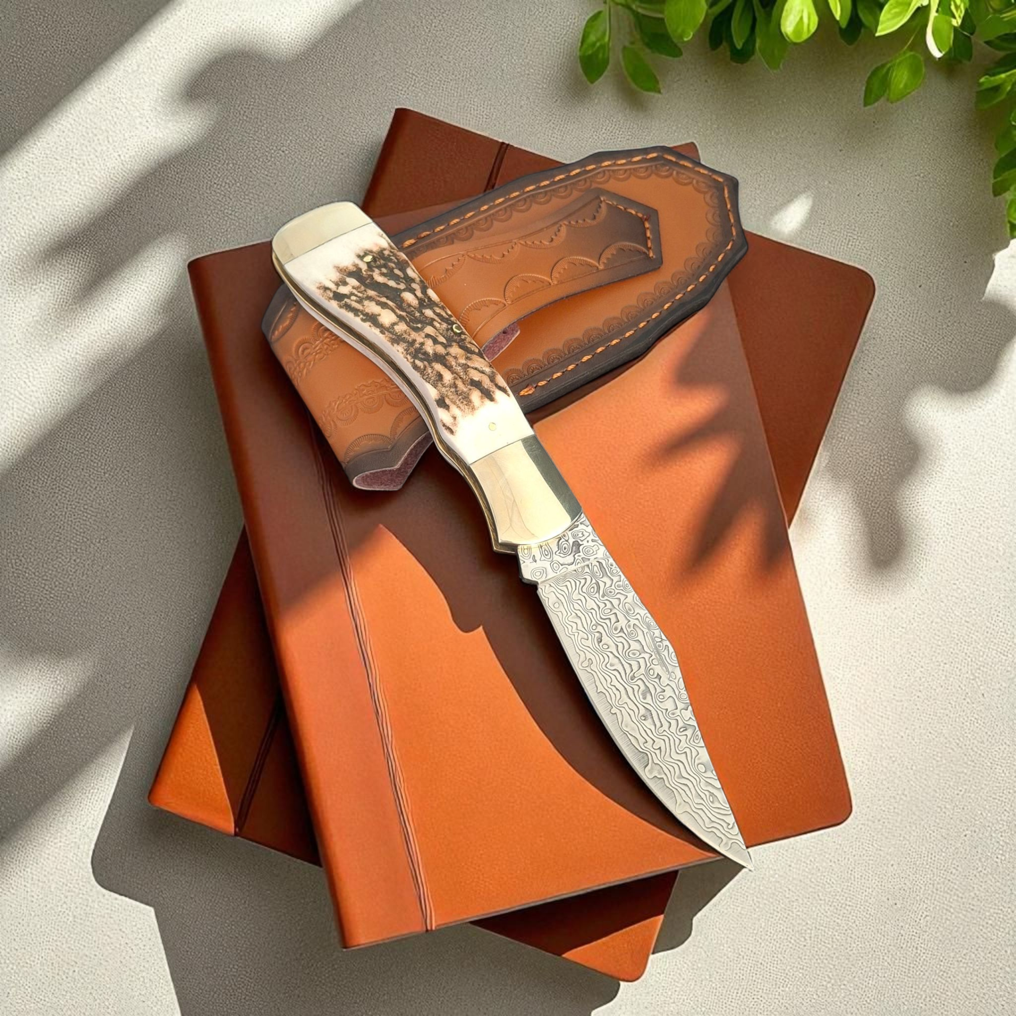 Сгъваем нож Stag Damascus Hunter с дамасково острие и кания върху бял фон