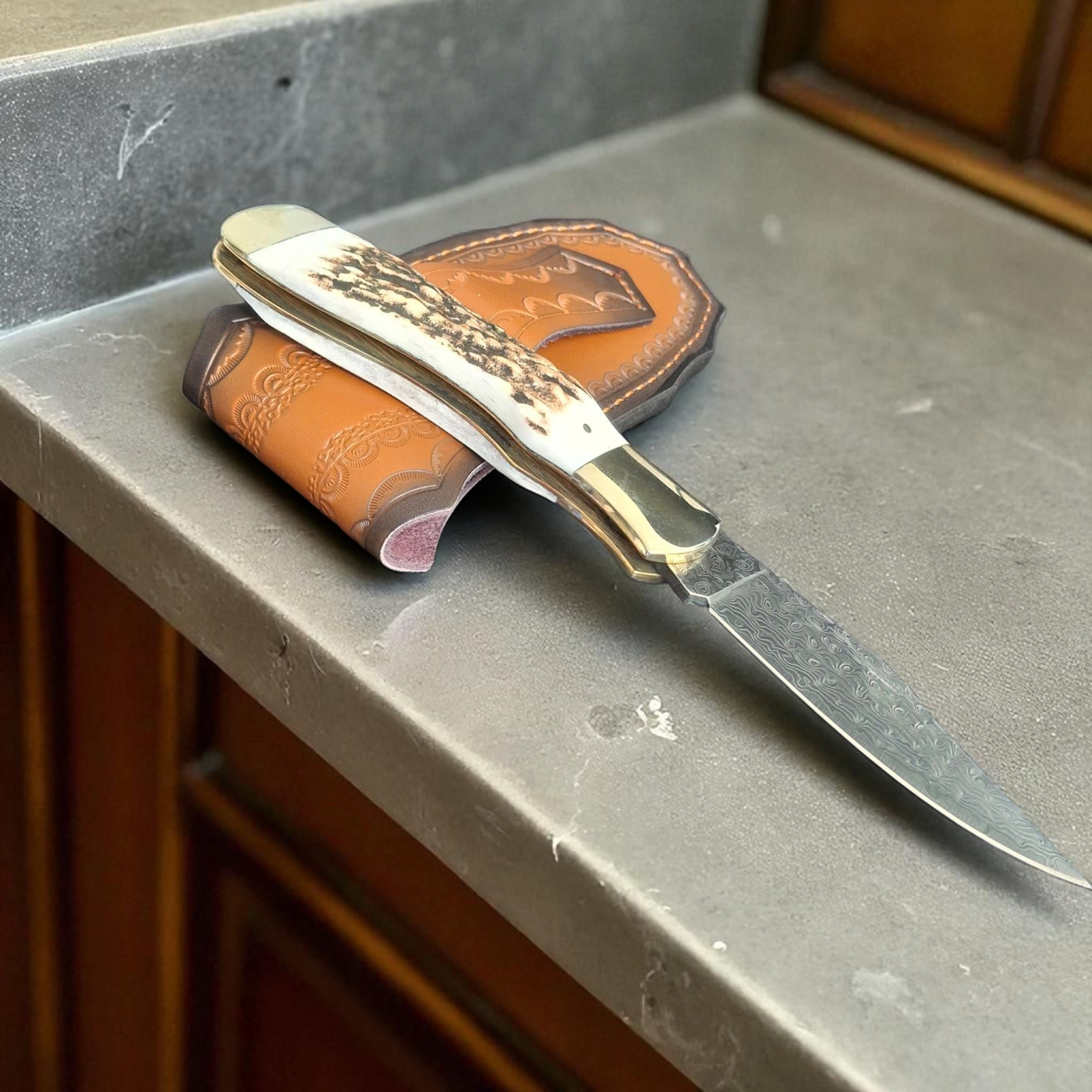 Сгъваем нож Stag Damascus Hunter с дамасково острие и кания върху бял фон