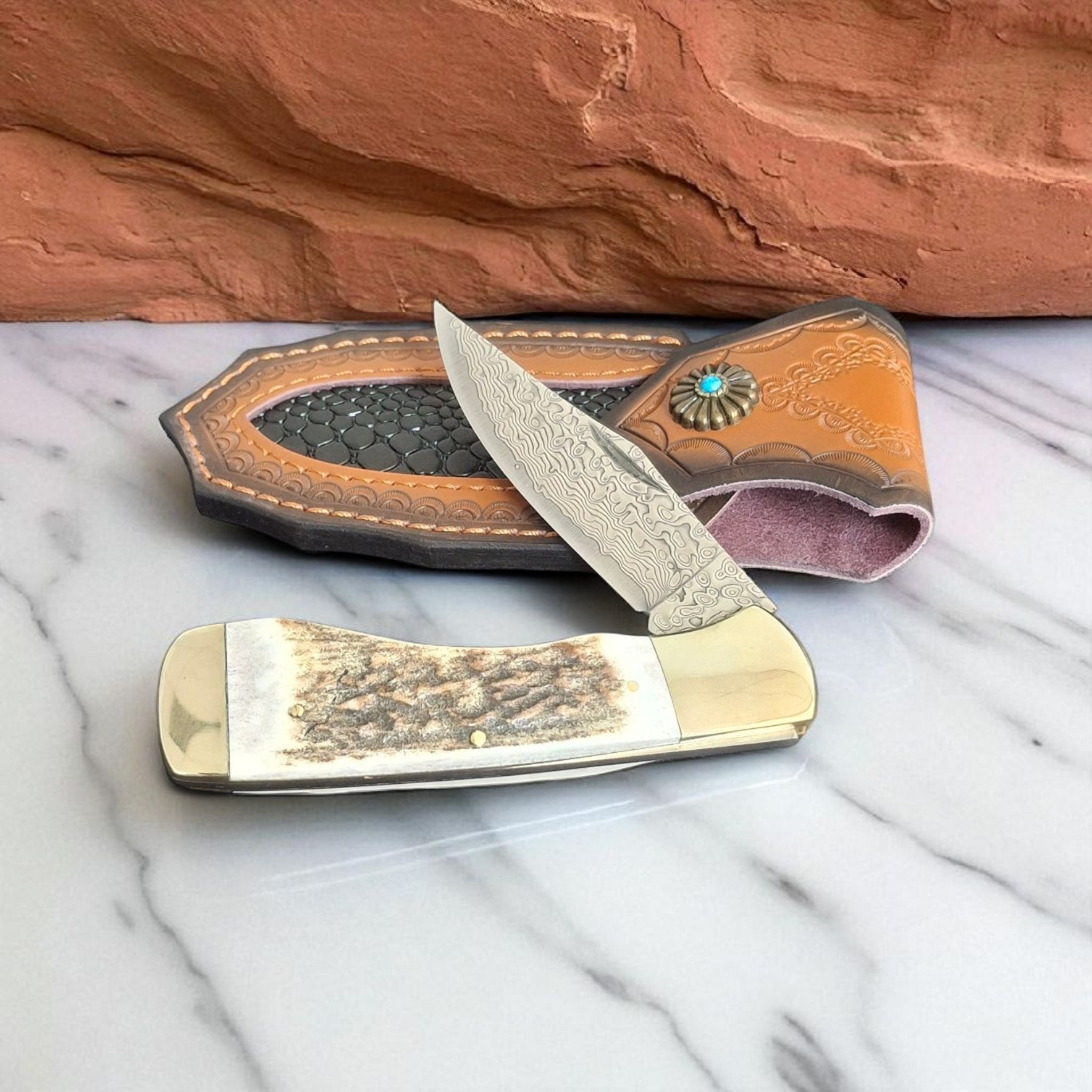 Сгъваем нож Stag Damascus Hunter с дамасково острие и кания върху бял фон