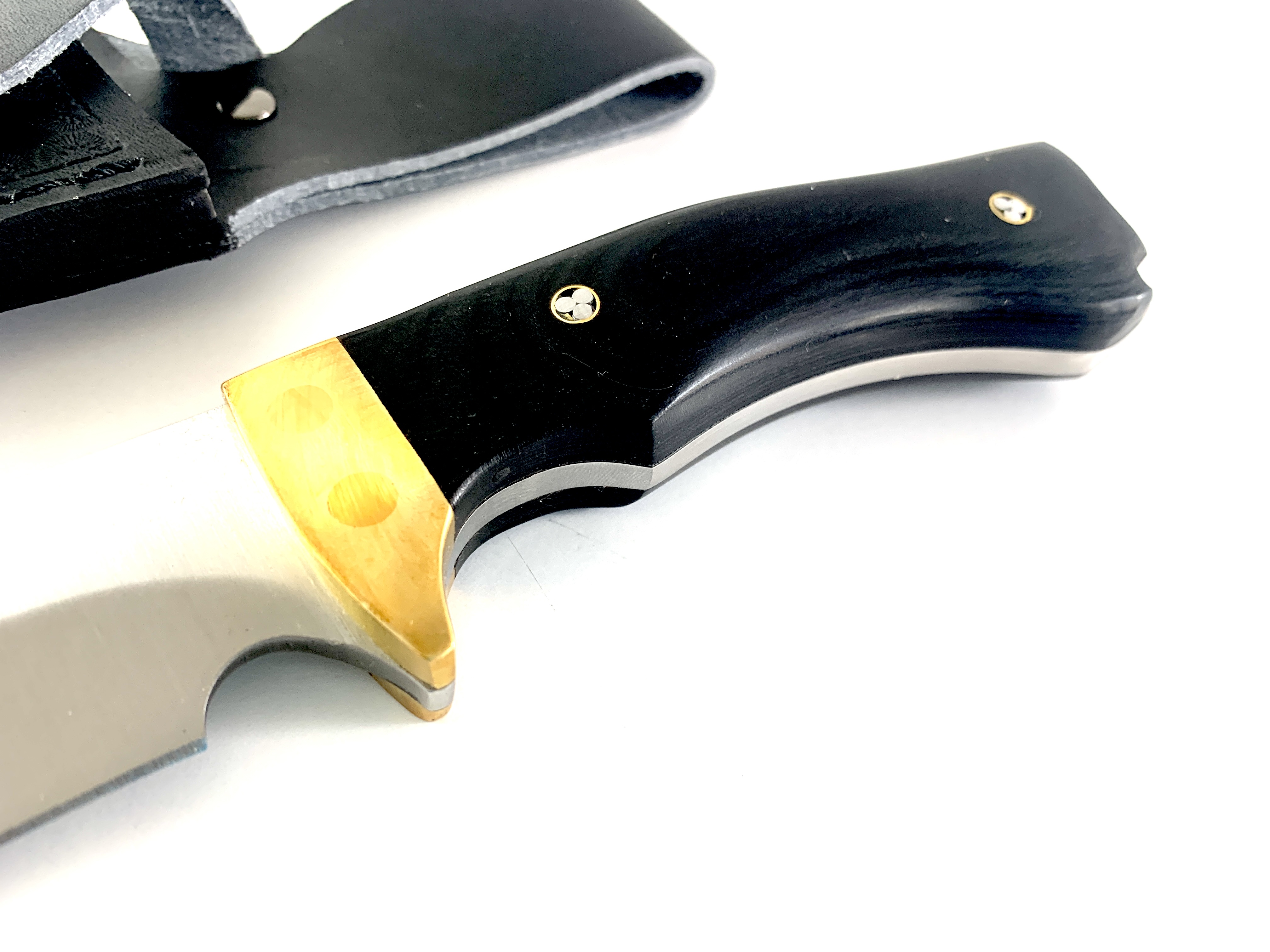 Продуктов кадър на нож Black Timber с открояваща се месингова гарда и кожена кания