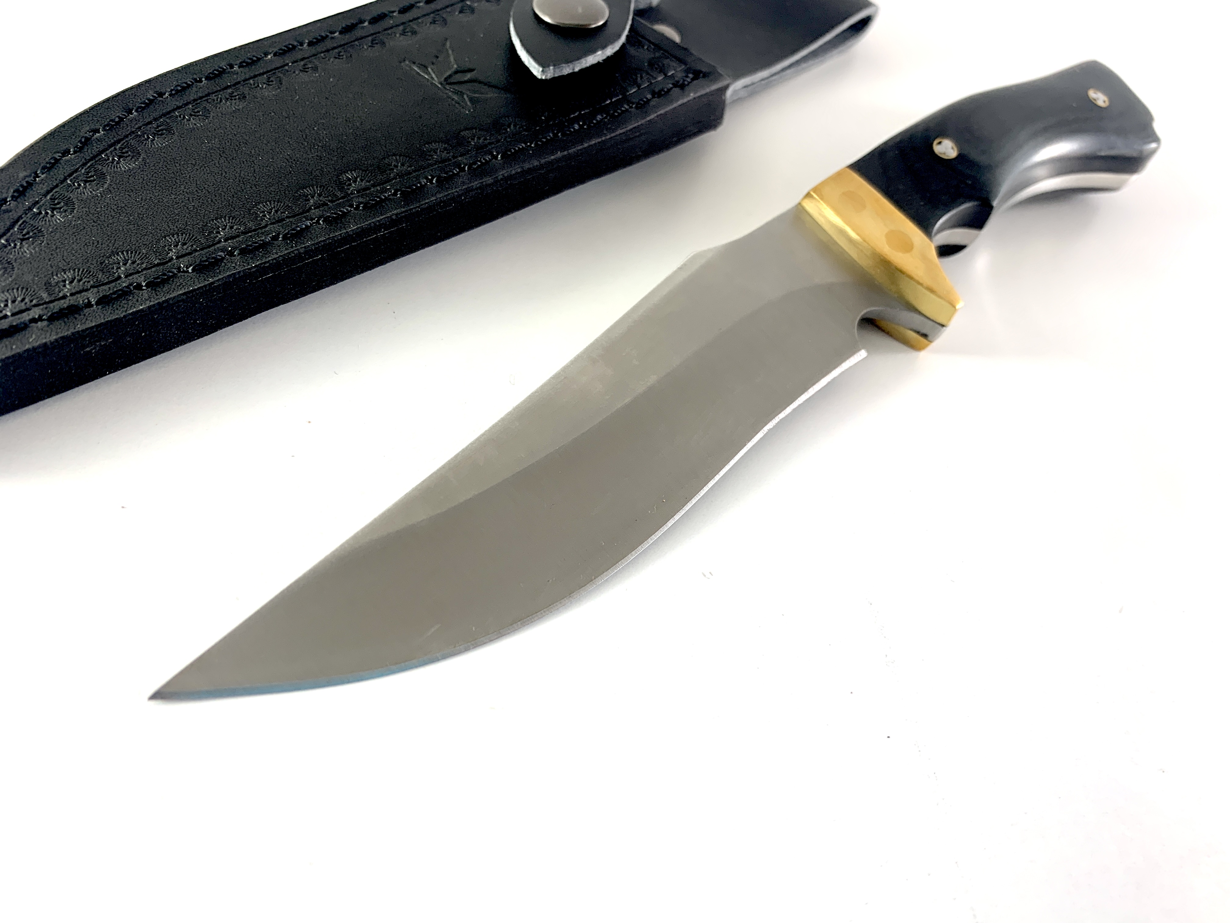 Продуктов кадър на нож Black Timber с открояваща се месингова гарда и кожена кания